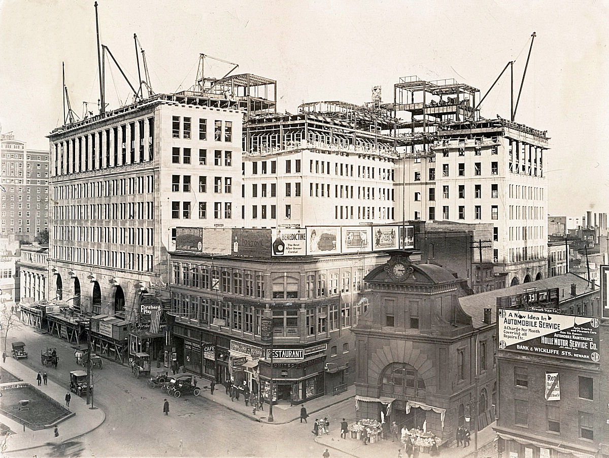 A 1915 photo of the construction of the Public Service Building.  The large building all the way to the left is the Robert Treat Hotel.  The facing of the side is different than what is there today.  The Military Park Building won't be built for another 11 years.  The low building directly to the left of the Public Service Building is the second American Insurance Building.  The company moved to its Washington Street building in 1930.  Immediately to the right of the PS Building is a theatre.  Depending upon the month this photo was taken it was either called Proctor's Newark Theatre of the Park Place Theatre.  In either case you can see that the Forsberg Players are performing there.  The old Centre Market is still there are will function for another 8 years.  You can see someone selling their goods at the entrance.  The market is above a still operating Morris Canal which ran below the market and Broad Street until it resurfaced east of the market.  Flanking the market is North & South Canal Streets.
